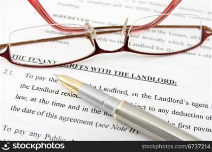 pen,glasses and tenant agreement with the landlord
