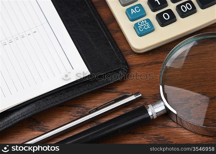 pen, magnifying glass and the diary