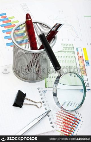 pen, magnifying glass and the working paper with a diagram