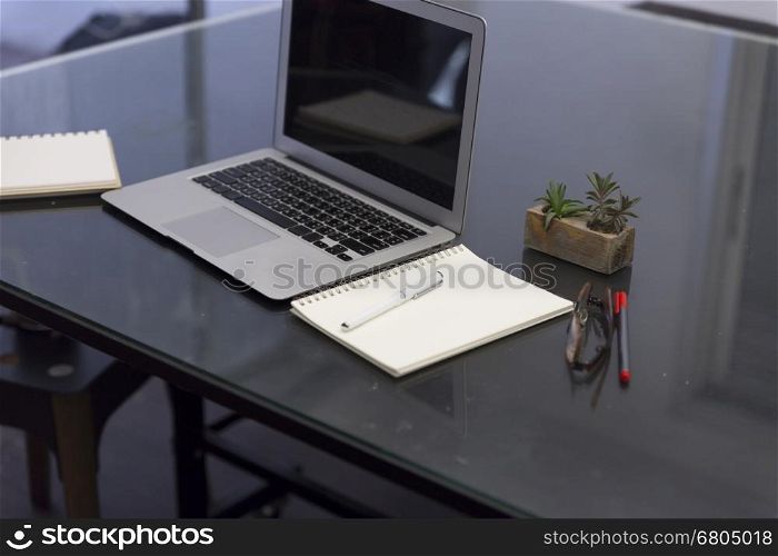 pen, notebook and laptop computer on black table for working concept