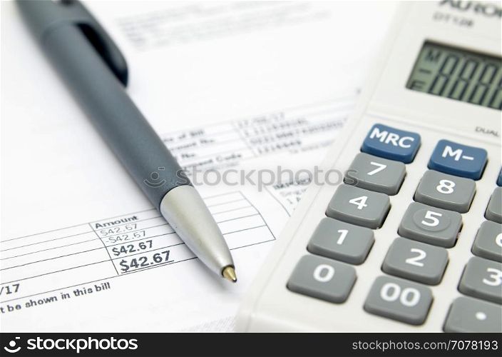 Pen on background of calculator and bill