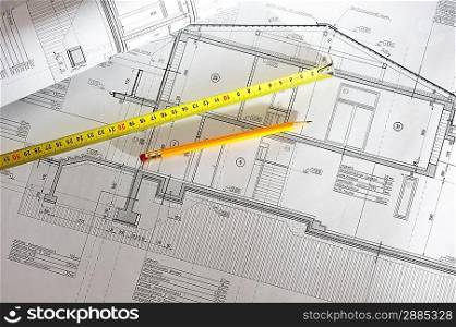 Pencil and tape meausure over house plan blueprints