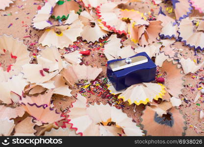 Pencil shapener on colorful pencil shavings