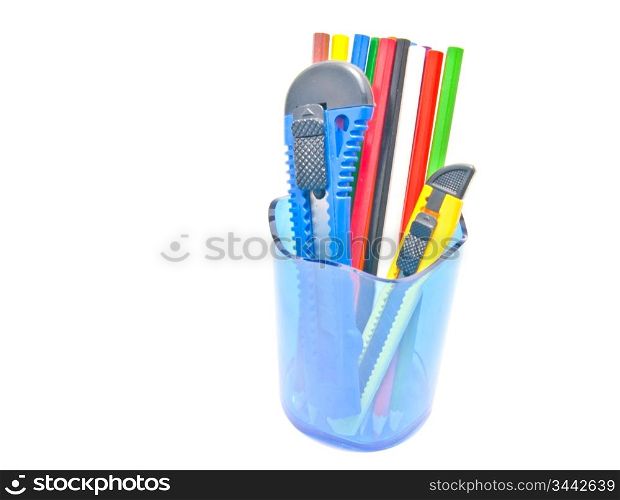 pencils and knifes in container close-up on white