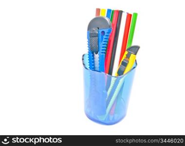 pencils and knifes in container on white background