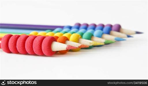 pencils arranged in color order of the rainbow on white background