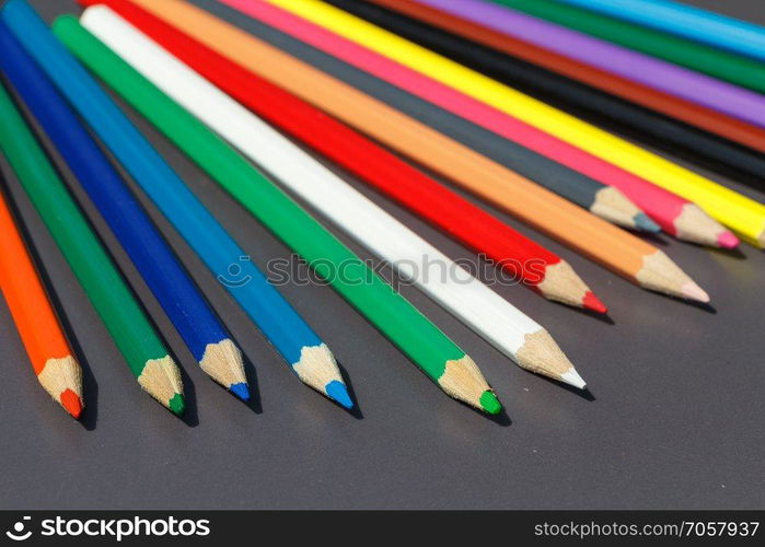 Pencils of different colors on gray background