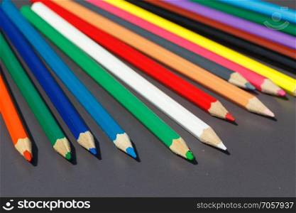 Pencils of different colors on gray background