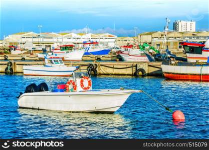 Peniche harbor, fishing boats, red buoy, docks in background, Portugal