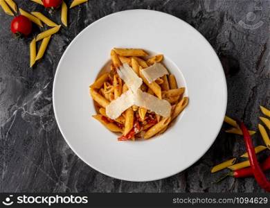 Penne pasta with a spicy sauce, chili pepper and grated parmesan cheese. penne with parmesan