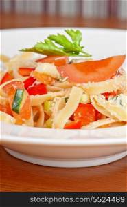 Penne pasta with parmesan cheese, herbs, tomatoes and basil