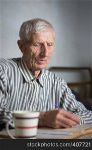 pensioner. portrait of senior man writing in a notebook
