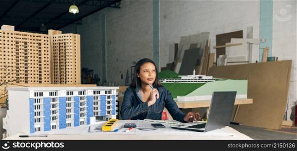 pensive african american lady with laptop model building