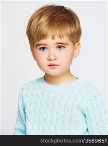 Pensive baby boy in blue pullover