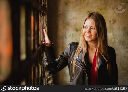 Pensive blonde woman next to a vintage windows