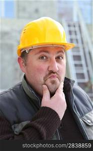 Pensive builder rubbing chin