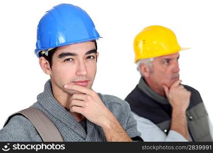 Pensive builder with young intern