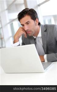 Pensive businessman in front of laptop