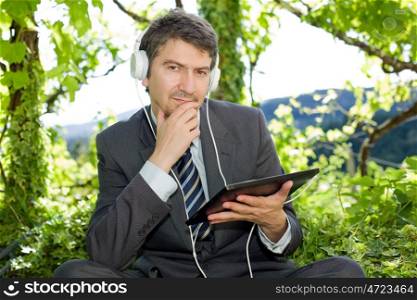 pensive businessman with digital tablet, outdoors
