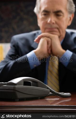 Pensive businessman with telephone