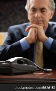 Pensive businessman with telephone