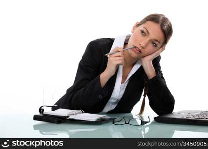 Pensive businesswoman sitting at a desk