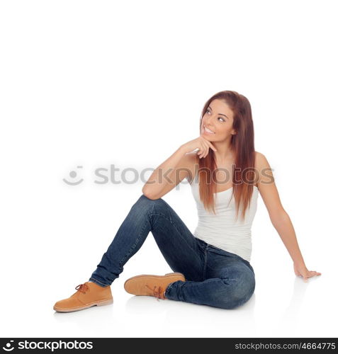 Pensive casual young woman sitting on the floor isolated on a white background