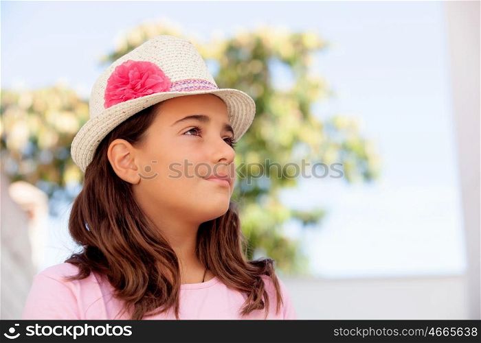 Pensive child girl ten year old with a hat on the street