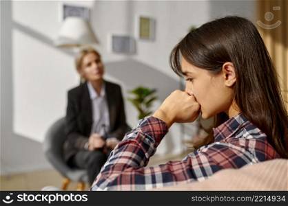 Pensive depressed woman at counseling session. Sad female listening psychologist advice biting fist. Pensive depressed woman at psychologist counseling session