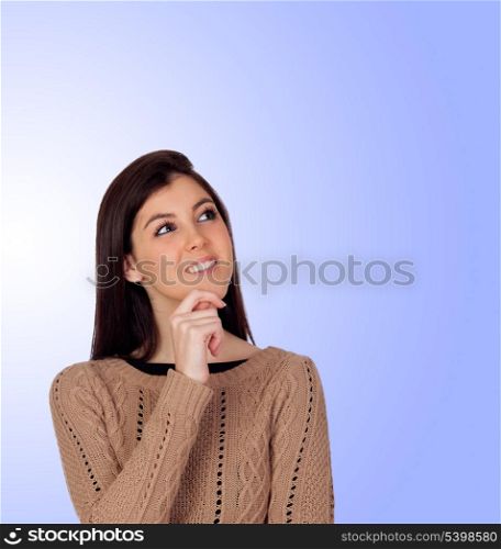 Pensive girl smiling isolated on a blue background
