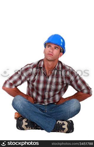 Pensive laborer sitting on the floor