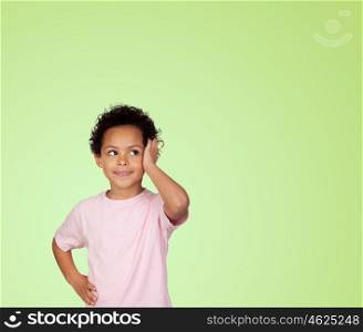 Pensive latin child isolated on green background