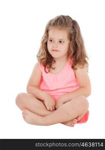 Pensive little girl sitting on the floor isolated on a white background