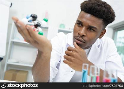 pensive man holding a molecule model