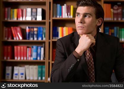 Pensive man wearing suit in library