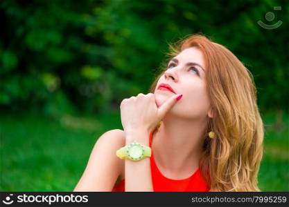 pensive portrait of a beautiful woman in a summer park