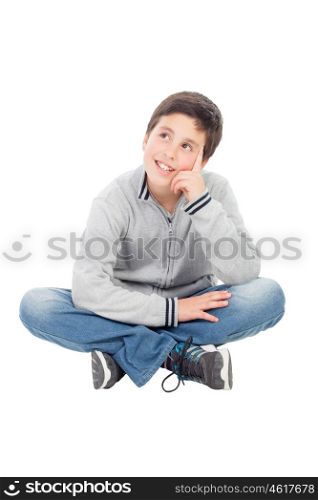 Pensive preteen boy sitting on the floor isolated on a white background