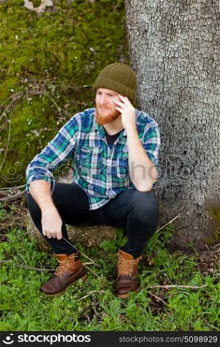 Pensive red haired man in th forest