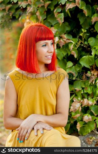 Pensive red haired woman in a park lit with a golden light