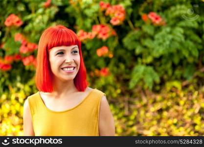 Pensive red haired woman in a park lit with a golden light