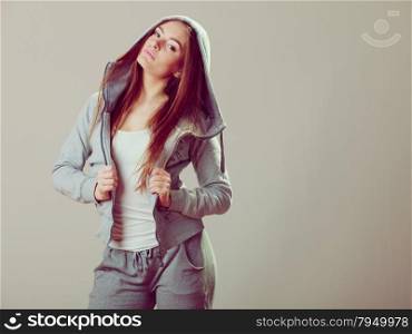 Pensive thoughtful teenager girl wearing sweatshirt with hood and white shirt. Teen fashion. Studio shot.