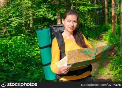 pensive tourist with map in a summer forest