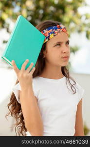 Pensive Twelve Year Old Student with a book outdoor