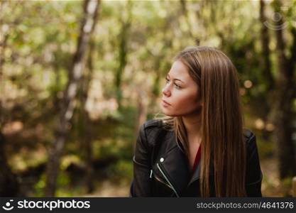 Pensive woman in a beautiful forest in autumn