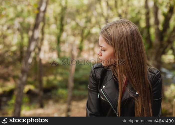 Pensive woman in a beautiful forest in autumn