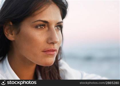 Pensive Woman on Beach looking out to sea, head shot, close up