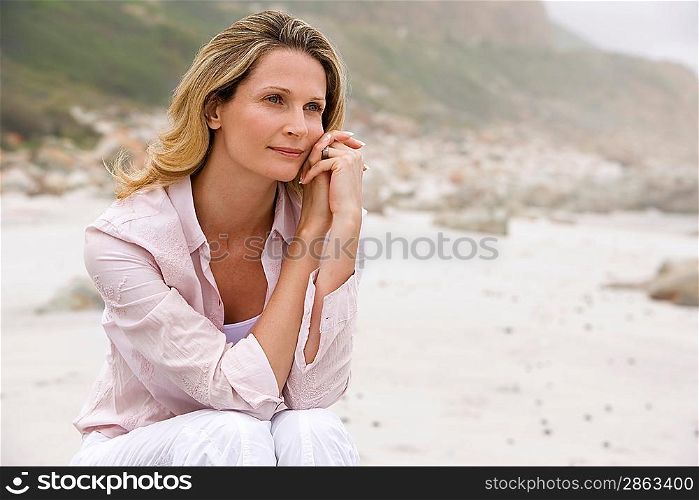 Pensive woman sitting on beach