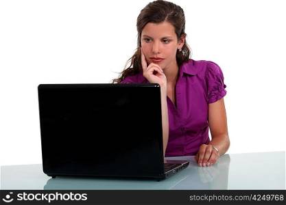 Pensive woman staring at her laptop