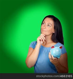 Pensive woman with a blue money-box on a over green background