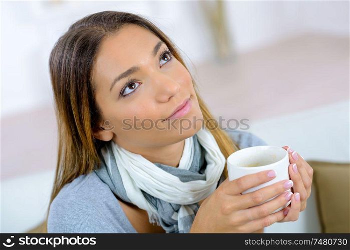 Pensive woman with a mug of coffee